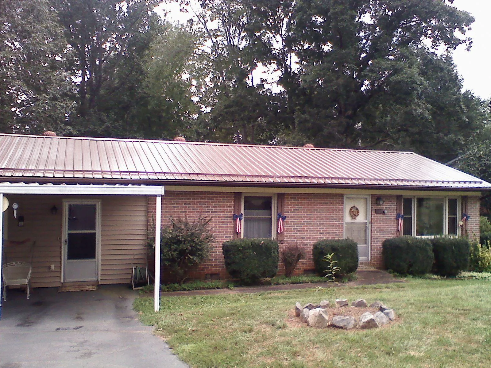 Bronze metal roof and carport on a brick ranch home — Roof Repair work by our crew in West Kingston
